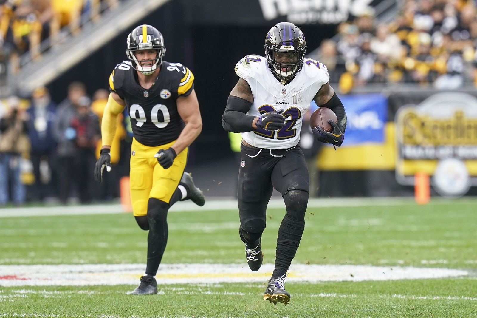 Baltimore Ravens running back Derrick Henry runs with the ball in front of Pittsburgh Steelers linebacker T.J. Watt during the first half Sunday in Pittsburgh.