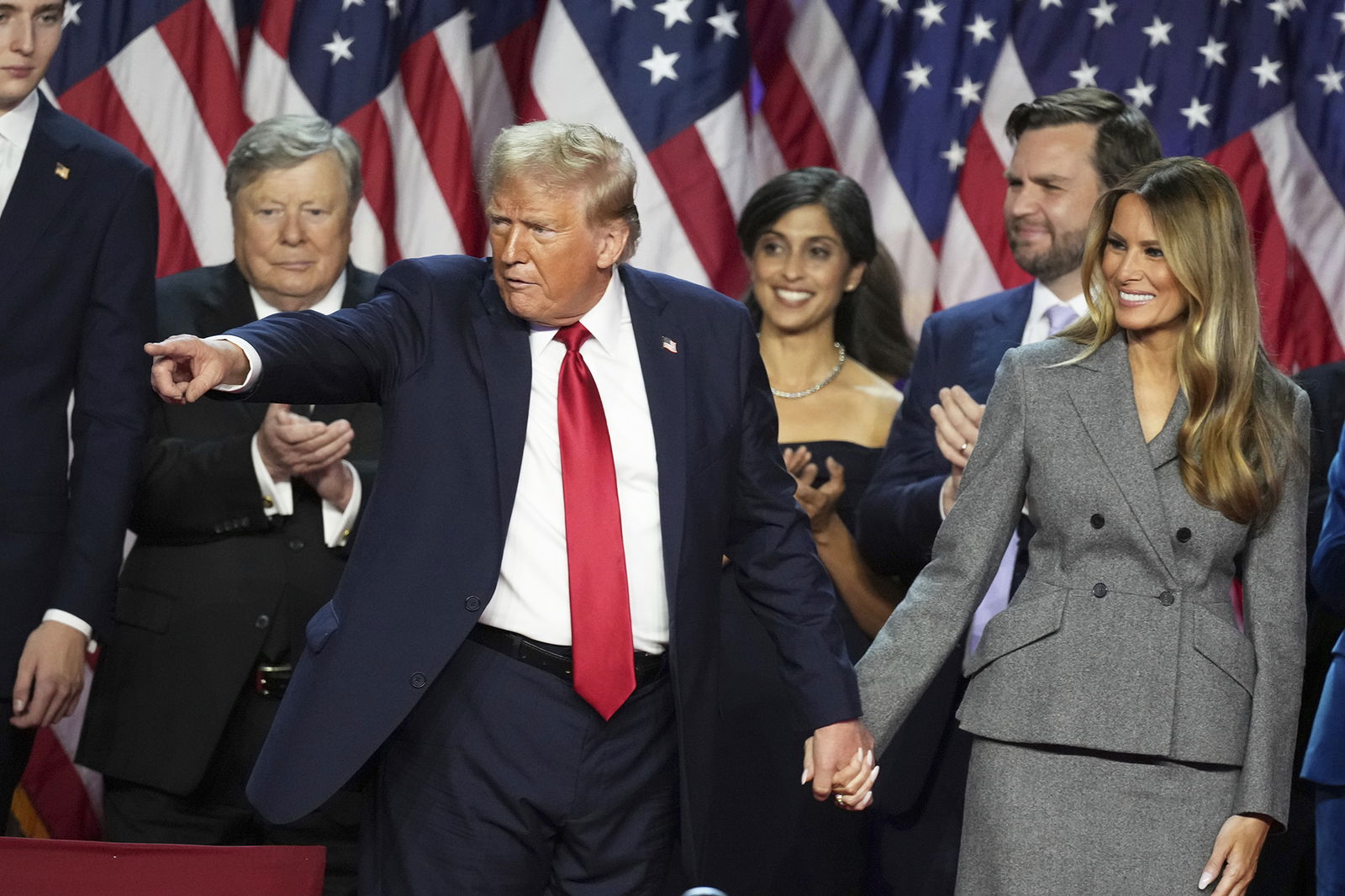 Republican Presidential nominee former President Donald Trump holds hands with former first lady Melania Trump after speaking to supporters at the Palm Beach County Convention Center during an election night watch party on Nov. 6 in West Palm Beach