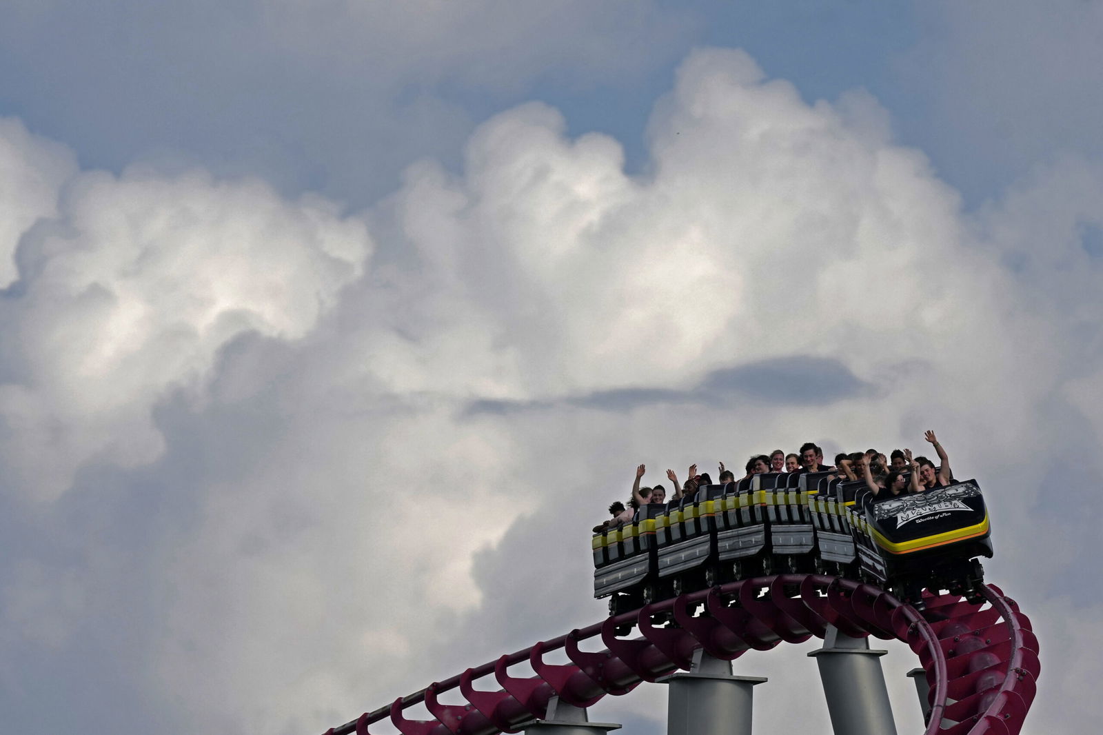 People ride on the Mamba roller coaster at Worlds of Fun theme park as storm clouds build in the distance June 21 in Kansas City
