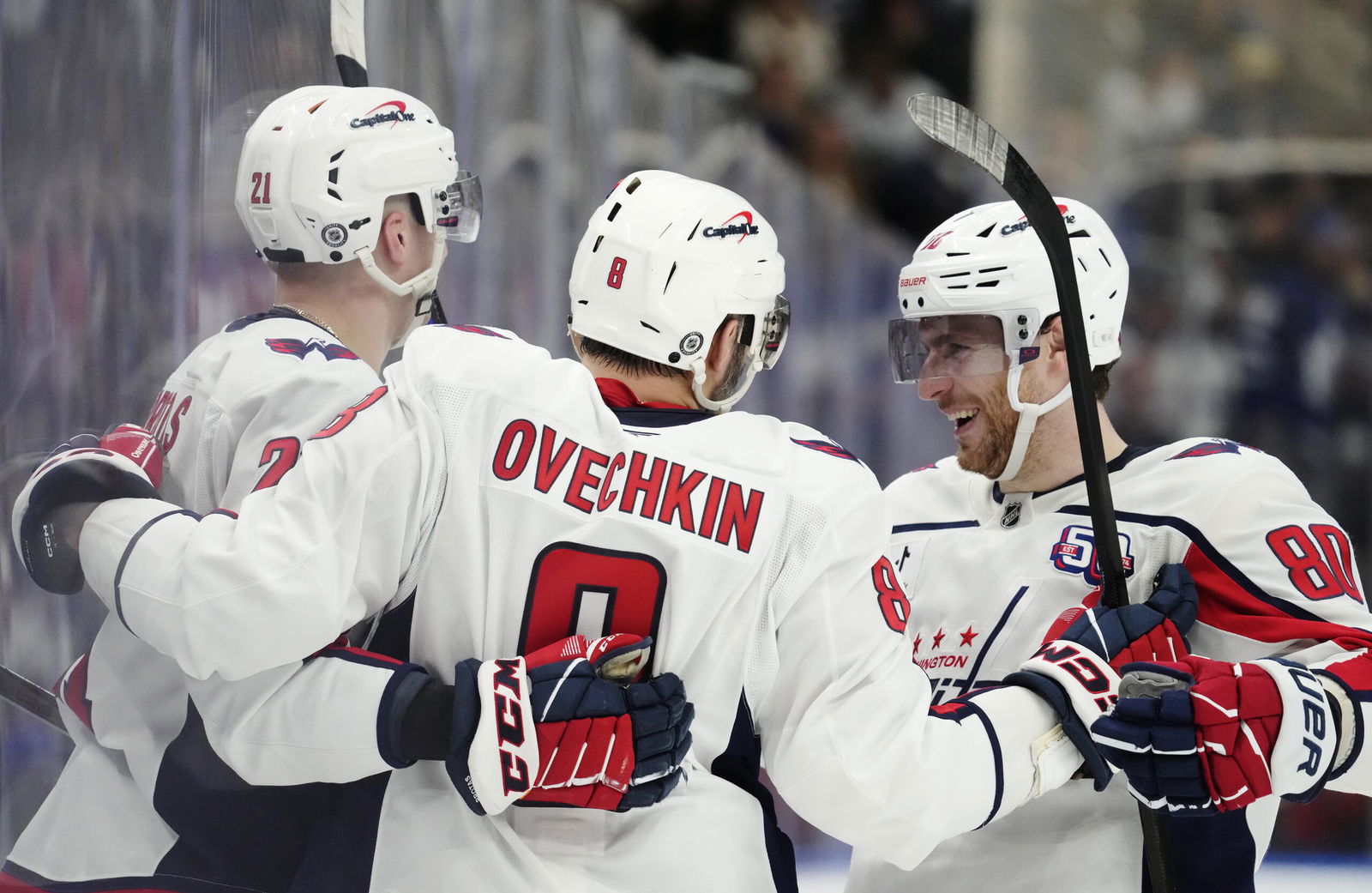 Washington Capitals' Alex Ovechkin (8) celebrates after his empty-net goal against the Toronto Maple Leafs with Aliaksei Protas (21) and Pierre-Luc Dubois (80) during third-period NHL hockey game action in Toronto