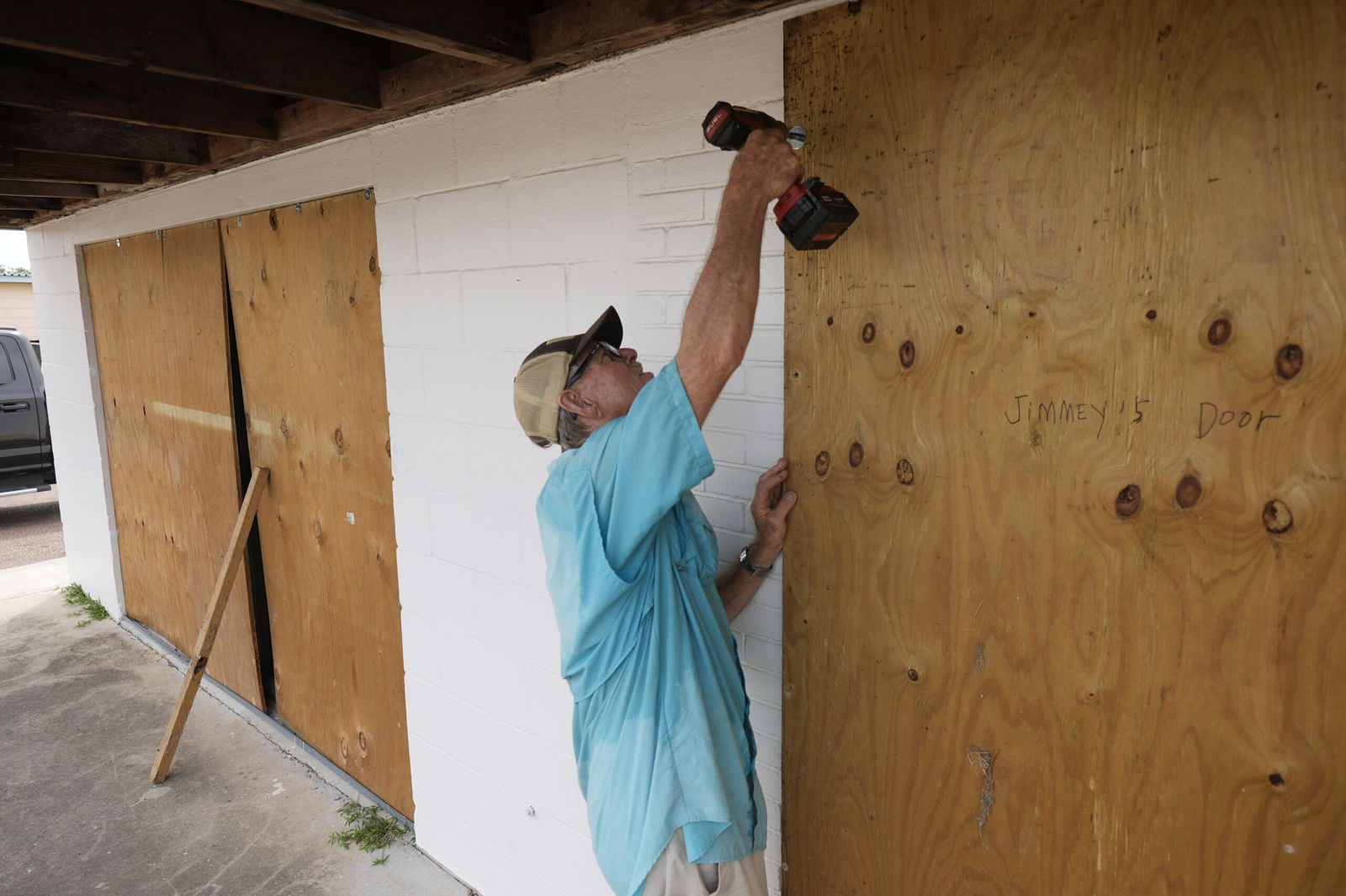 Jimmy May boards windows as he prepares for Hurricane Beryl’s arrival