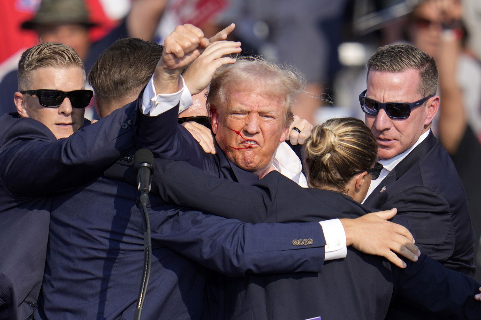 Republican presidential candidate former President Donald Trump pumps his fist as he is helped off the stage at a campaign event July 13 in Butler