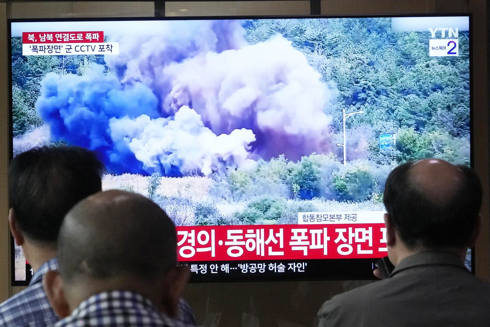 A TV screen reports North Korea has blown up parts of northern side of inter-Korean roads during a news program Tuesday at Seoul Railway Station in Seoul