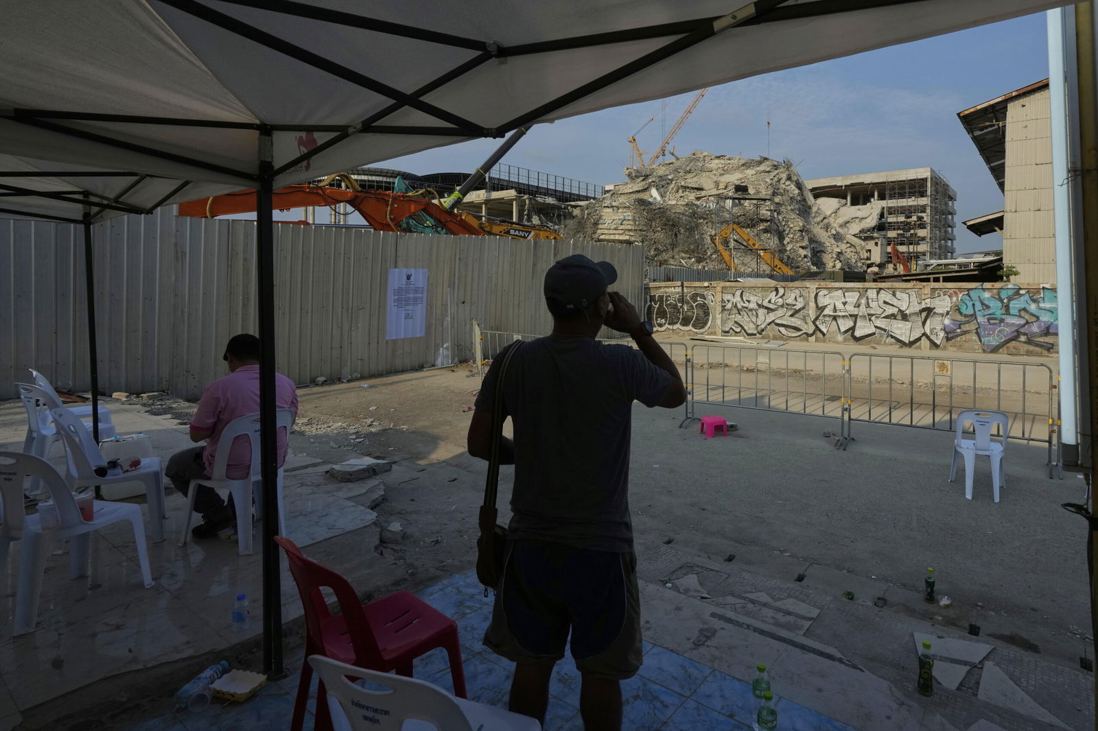 A person watches at site of an under construction high-rise building that collapsed after an earthquake in Bangkok