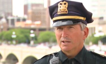 A tense situation unfolded in Des Moines on May 25 when a man perched precariously outside the guardrail of the 5th Avenue parking garage