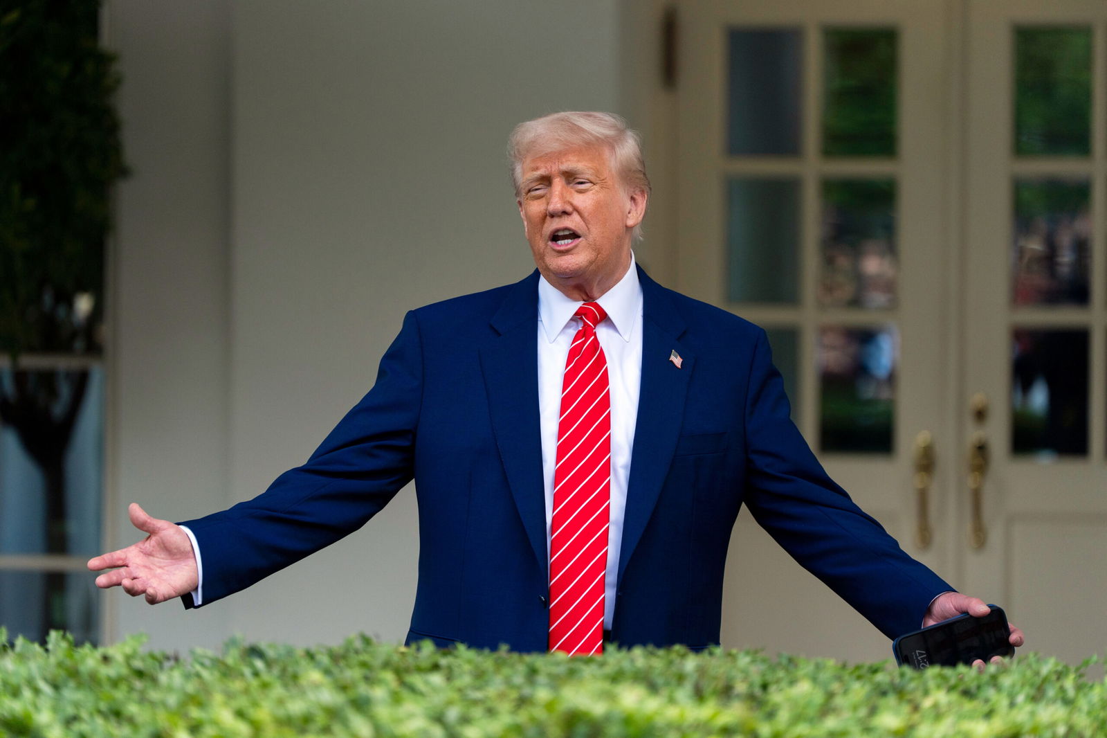 President Donald Trump speaks with reporters in front of the West Wing of the White House