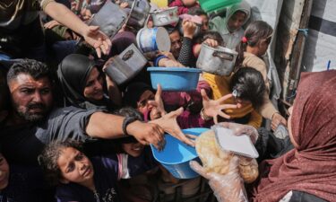 A child carries a tray of food past a tent sheltering displaced Palestinians inside the destroyed Rashad Al-Shawa Cultural Center in Gaza City on April 21.