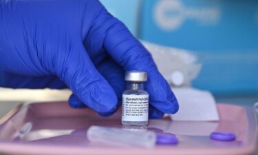 A nurse reaches for a vial of Pfizer-BioNTech Covid-19 vaccine at a pop up vaccine clinic in the Arleta neighborhood of Los Angeles