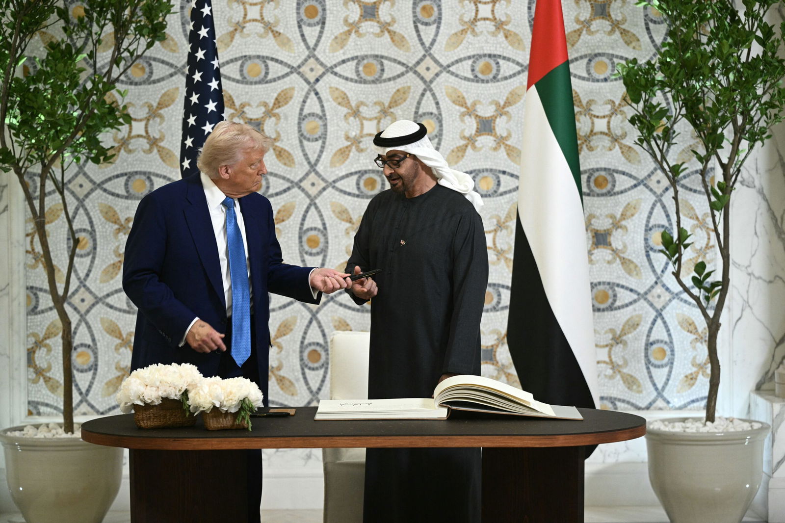 <i>Brendan Smialowski/AFP/Getty Images via CNN Newsource</i><br/>US President Donald Trump returns the pen to his UAE counterpart Sheikh Mohamed bin Zayed Al Nahyan
