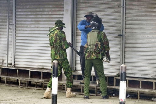 ADDS NAME: Kenyan police speak to vendor Boniface Kariuki before one of the policemen