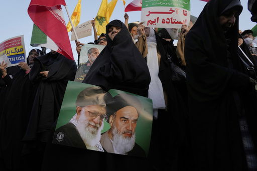 An Iranian woman holds a poster of the late revolutionary founder Ayatollah Khomeini
