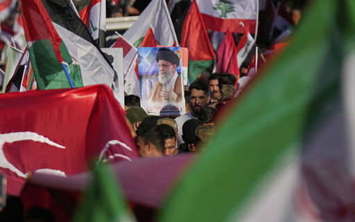 A protest holds a portrait of Iran's Supreme Leader Ayatollah Ali Khamenei during a rally to show solidarity with Iran in the Shi'ite district of Kazimiyah