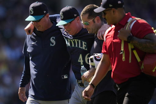 Seattle Mariners pitcher Trent Thornton (46) is helped off the field after suffering from heat exhaustion during the eighth inning of a baseball game against the Chicago Cubs