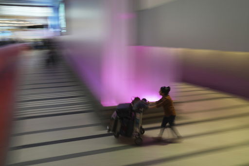 A traveler pushes a luggage cart through the international arrivals area at the international airport in Los Angeles