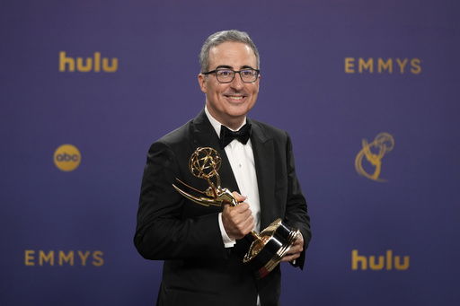 FILE - John Oliver poses in the press room with the award for outstanding scripted variety series for