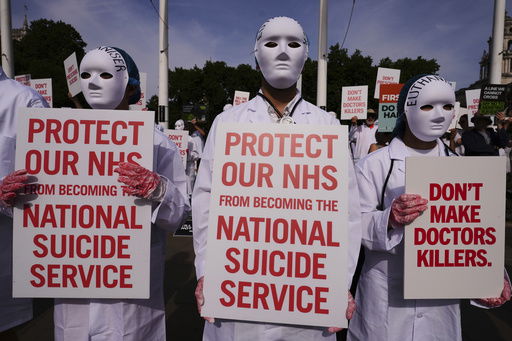 Demonstrators against assisted dying hold banners outside Parliament in London
