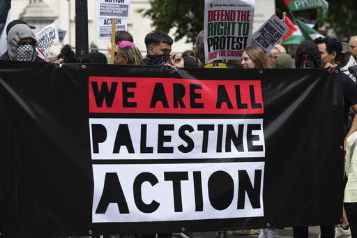 Demonstrators hold up a banner during a protest by Palestine Action group in London