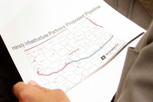 North Dakota Republican Gov. Kelly Armstrong holds a map of a proposed natural gas pipeline on Thursday