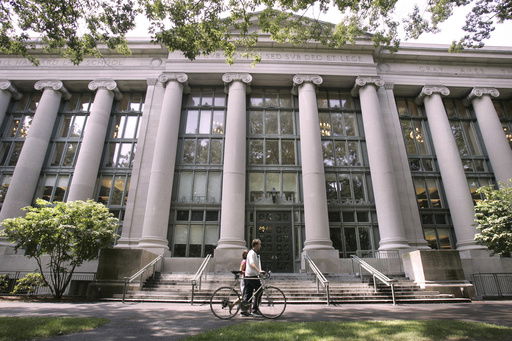 FILE - A bicyclist walks by Langdell Hall