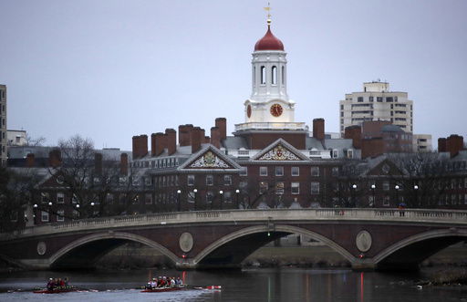 FILE - Rowers paddle down the Charles River near the campus of Harvard University in Cambridge