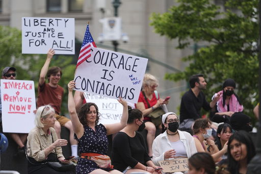 Demonstrators hold signs during a protest against deportation by Immigration and Customs Enforcement Thursday