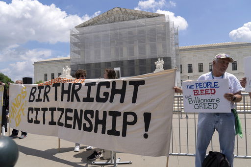 FILE - Demonstrators holds up a banner during a citizenship rally outside of the Supreme Court in Washington