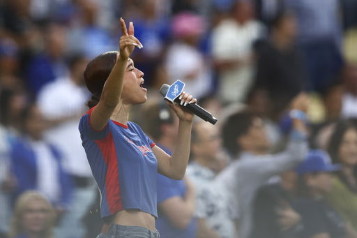 FILE - Music artist Nezza sings the national anthem prior to a baseball game between the Los Angeles Dodgers and the San Francisco Giants in Los Angeles