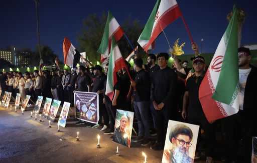 Protesters gather in front of the Iranian embassy carrying candles and Iranian flags during a stand honoring the Iranian armed forces generals