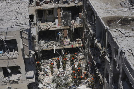Israeli soldiers dig through rubble to search for survivors in a residential area hit by a missile fired from Iran