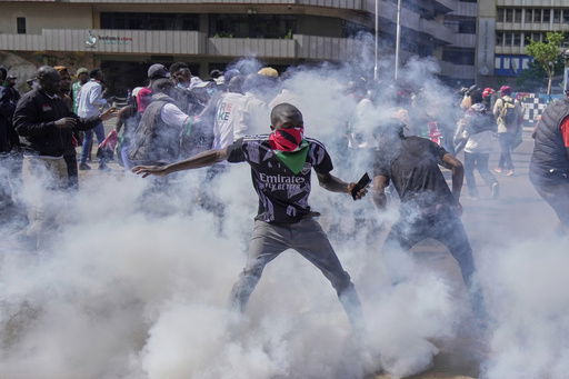 Protesters scatter as police fire teargas at them during a demonstration in downtown Nairobi