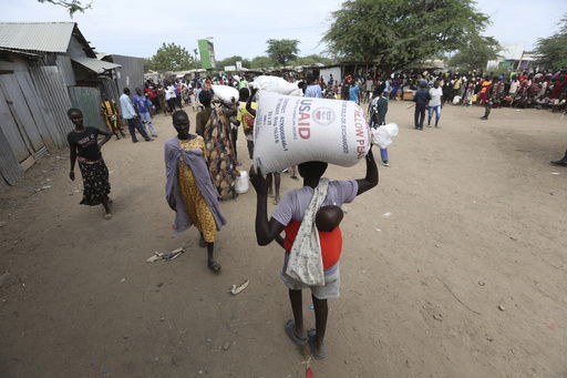 Refugees carry food at a distribution center run by the World Food Programme (WFP) at Kakuma Refugee Camp in Turkana