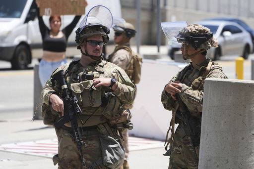 Members of the California National Guard and U.S. Marines guard a federal building on Tuesday