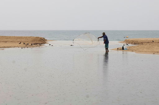 A fisherman throws a net in Puerto Escondido