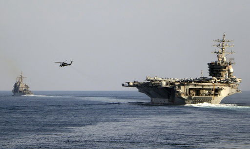 FILE - The aircraft carrier USS Dwight D. Eisenhower and other warships crosses the Strait of Hormuz into the Persian Gulf on Sunday