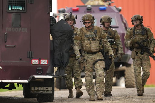 Members of law enforcement agencies search for shooting suspect