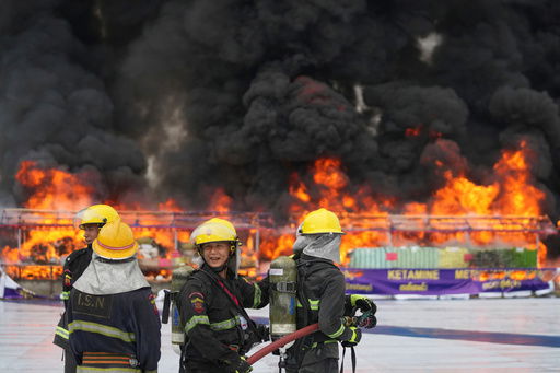 Firefighters stand by near burning illegal narcotics during a destruction ceremony to mark International Day against Drug Abuse and Illicit Trafficking