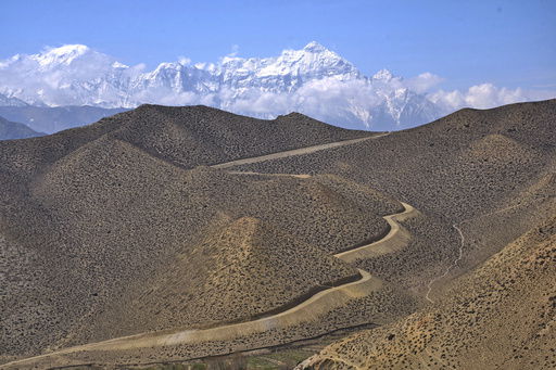 A dirt road through a barren mountains leads to the abandoned Samjung village in the Mustang region