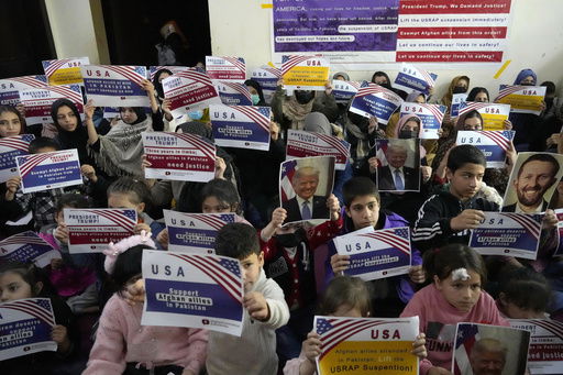FILE - Afghan refugees hold placards during their meeting to discuss situation after President Donald Trump paused the U.S. refugee programs