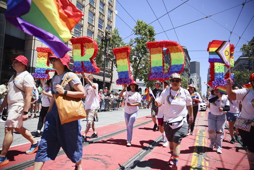 FILE - Revelers walk along Market Street during a Pride Parade