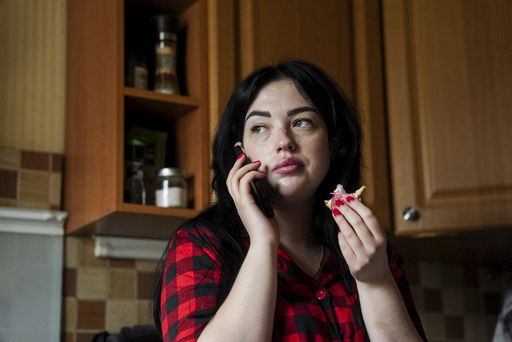 Olha Kurtmalaieva speaks via a phone while having a breakfast at her apartment in Kyiv