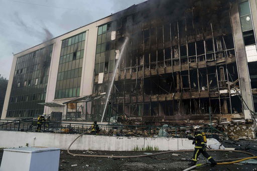 FILE - Rescue workers put out a fire of a building damaged by a Russian drone strike on Kyiv