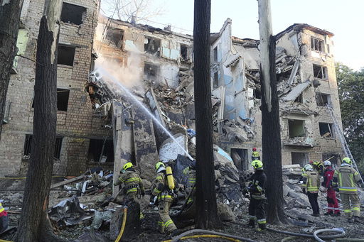Firefighters work to extinguish a fire in an apartment building after Russian attack in Kyiv