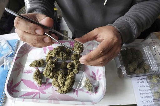 A staff prepares flower bud of marijuana for a customer at a cannabis shop after Thailand started banning the sale of cannabis to those without a prescription in Bangkok
