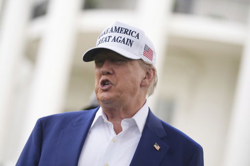 President Donald Trump speaks as a flag pole is installed on the South Lawn of the White House