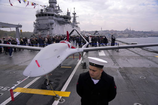 FILE - A navy soldier stands next to an unmanned combat aerial vehicle (UCAV) Bayraktar TB3 on board the Turkish amphibious assault ship TCG Anadolu L400