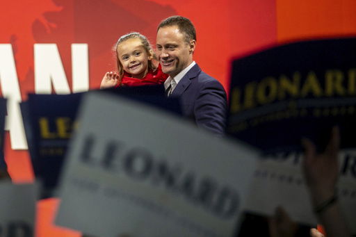 FILE - Former Michigan State Representative Tom Leonard who is running for the republican Attorney General nomination greets supporters while holding his daughter on stage during the Michigan Republican convention at Devos Place in Grand Rapids