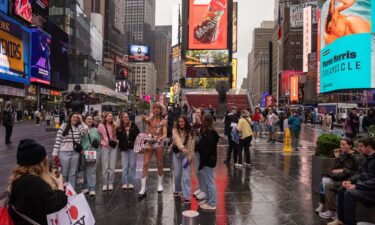 Tourists take a photo with the Naked Cowboy in Times Square on May 9