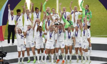 England's Leah Williamson and Millie Bright lift the trophy as they celebrate with teammates after winning Women's Euro 2022.