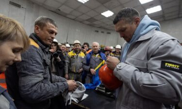 Oleksandr Usyk signs a protective helmet in March as he visits a thermal power plant in Ukraine that had been damaged by Russian missile strikes.