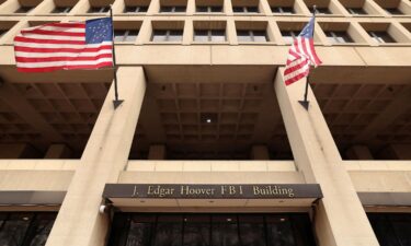 Flags fly over an entrance to FBI headquarters.